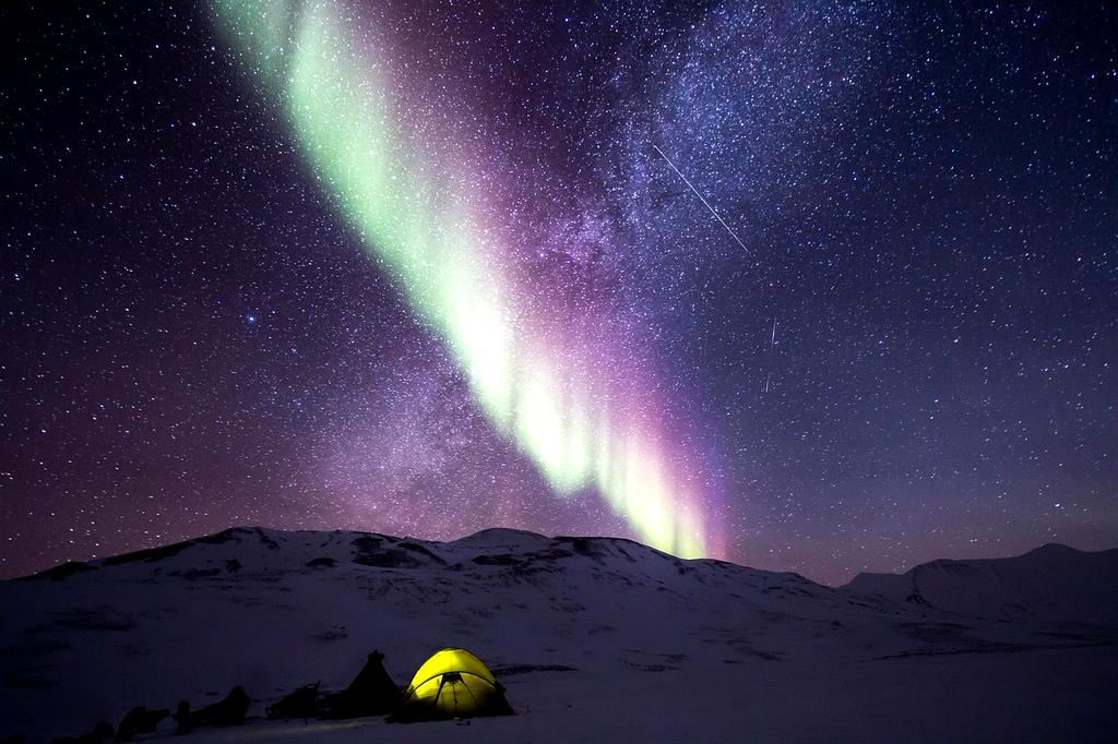 Aurora borealis dancing over snowy Icelandic landscape
